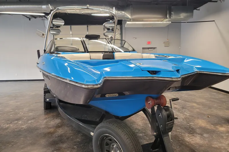 Slide: The Image of 2014 Malibu Wakesetter 24 MXZ boat in showroom, blue exterior, on trailer. - 3