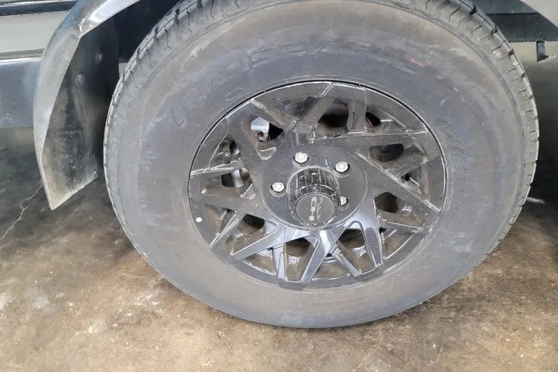 Slide: The Image of 2014 Malibu Wakesetter 24 MXZ trailer wheel with black alloy rim. - 8