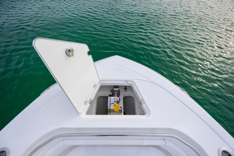 Slide: The Image of Bow of 2026 Caymas 291 boat with open hatch, on calm green water. - 13