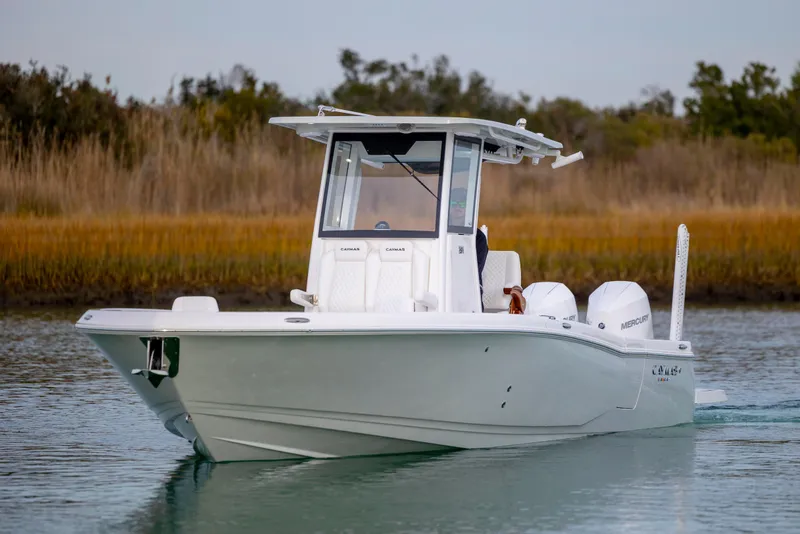 Slide: The Image of 2026 Caymas 291 boat cruising on calm water with scenic background. - 2