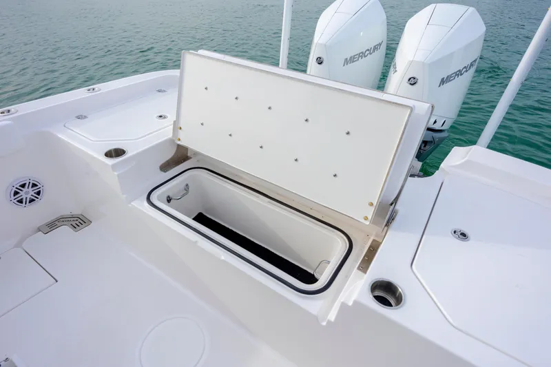 Slide: The Image of 2026 Caymas 291 boat with open storage compartment and dual Mercury engines. - 31