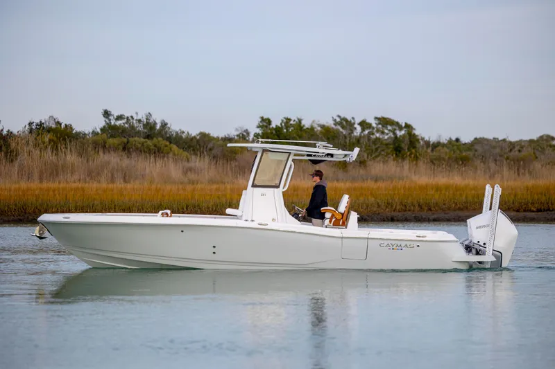 Slide: The Image of 2026 Caymas 291 boat cruising on calm water with scenic background. - 4