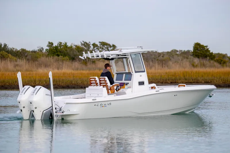 Slide: The Image of 2026 Caymas 291 boat cruising on calm water with dual Mercury engines. - 7