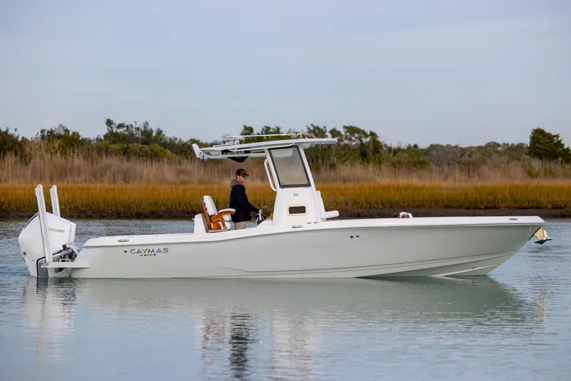 Slide: The Image of 2026 Caymas 291 boat on calm water, side view with trees in the background. - 9