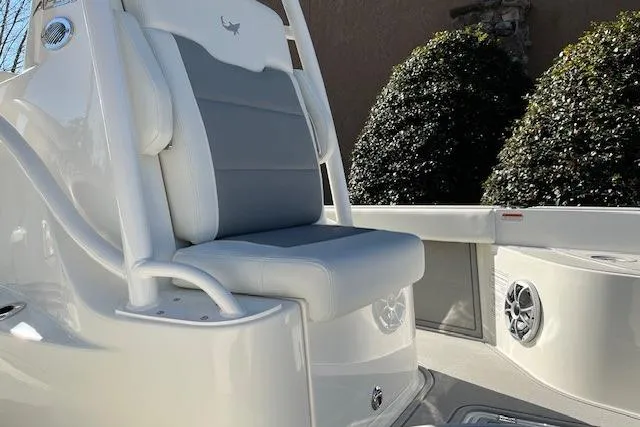 Slide: The Image of 2026 Mako 24 APEX boat interior with cushioned seating and speaker system. - 4