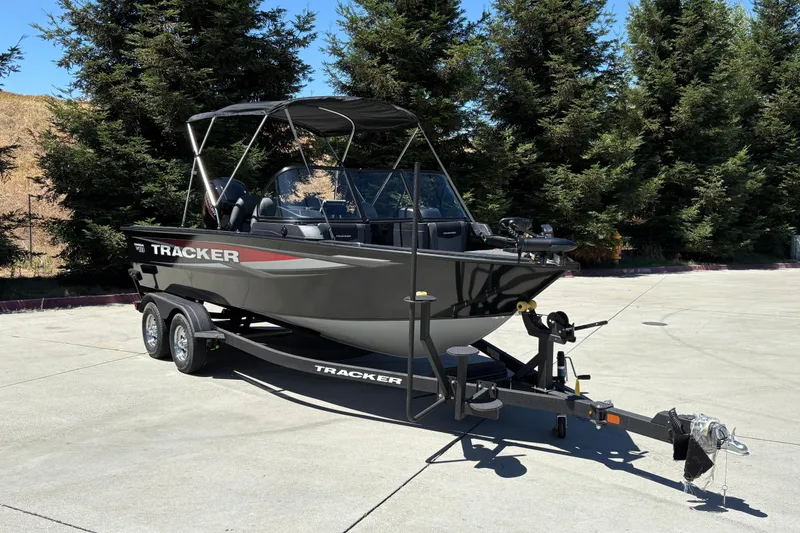 Slide: The Image of 2026 Tracker Targa V-18 Combo boat on trailer, parked outdoors near trees. - 3