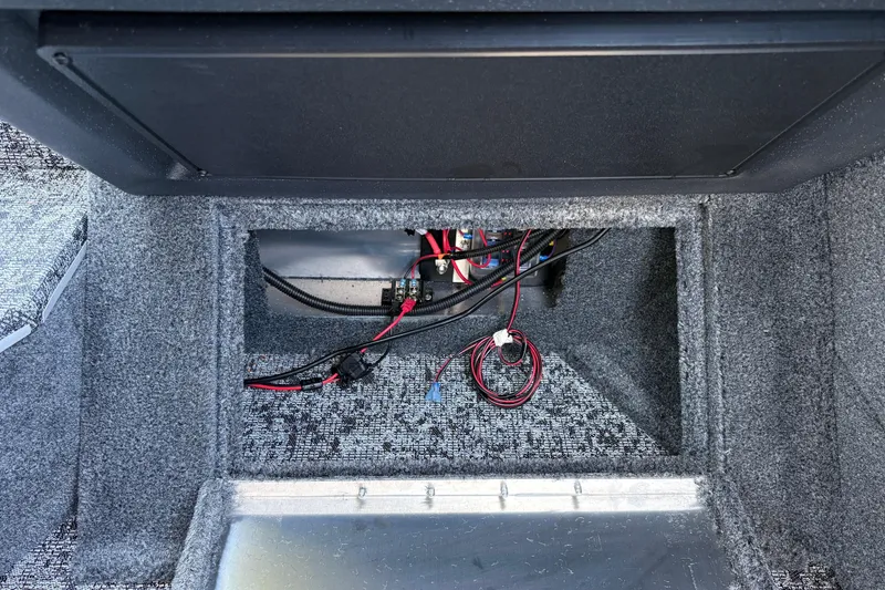Slide: The Image of Interior compartment of 2026 Tracker Targa V-18 Combo boat, showing wiring and storage space. - 50