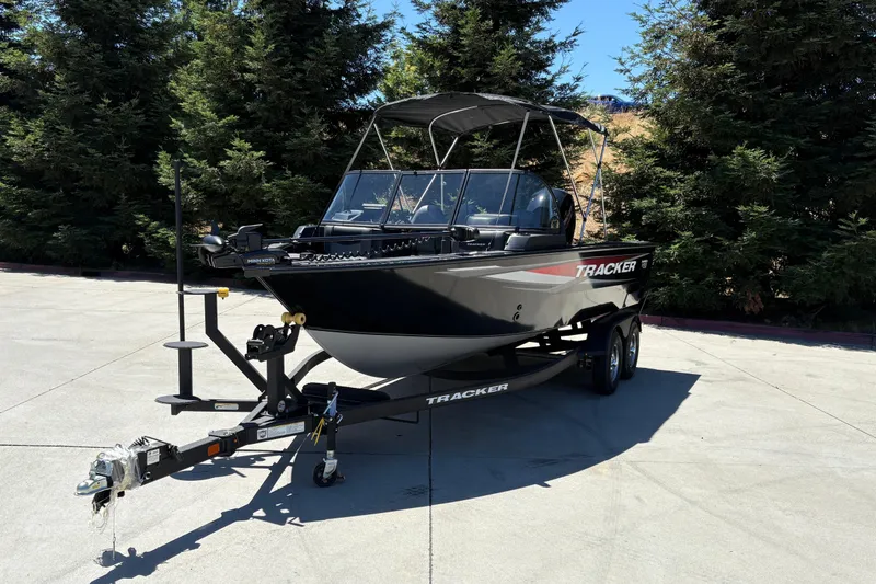 Slide: The Image of 2026 Tracker Targa V-18 Combo boat on trailer, parked outdoors with trees in background. - 8