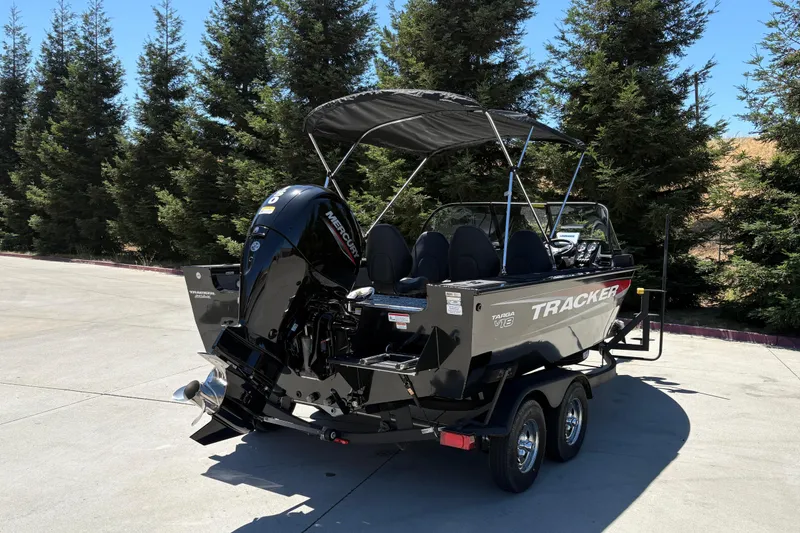 Slide: The Image of 2026 Tracker Targa V-18 Combo boat with outboard motor, parked on a trailer. - 13
