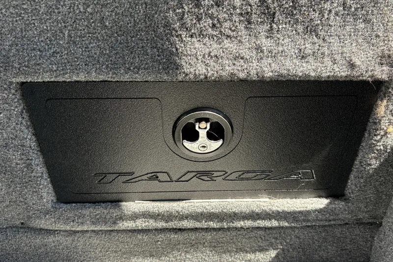 Slide: The Image of 2026 Tracker Targa V-18 Combo storage compartment with lock, featuring carpeted interior. - 42