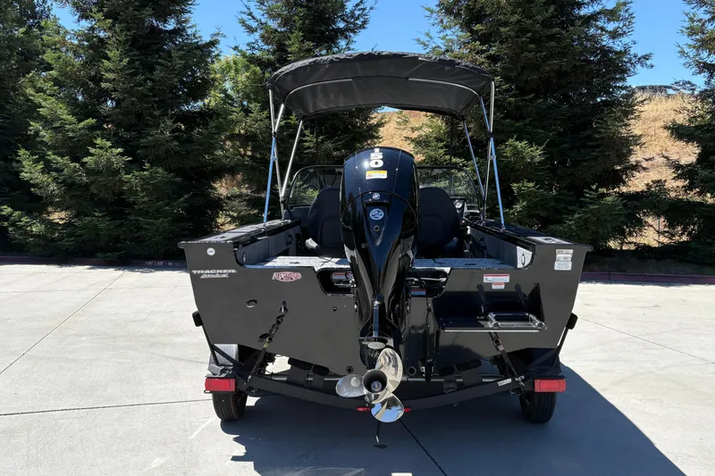 Slide: The Image of 2026 Tracker Targa V-18 Combo boat with outboard motor, parked outdoors. - 14
