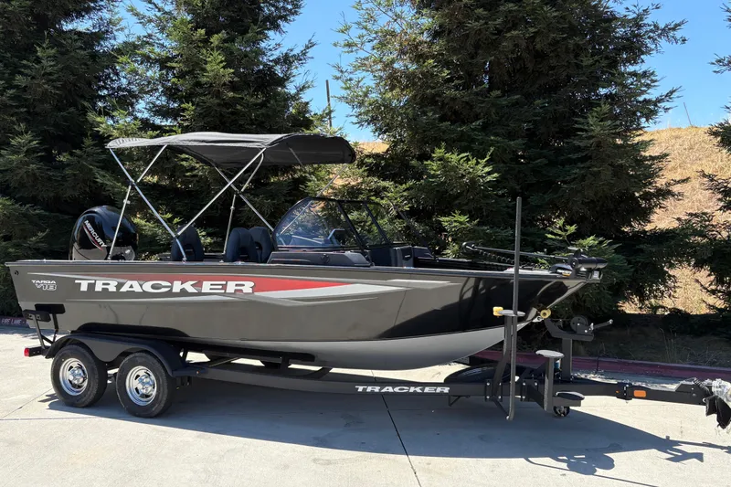 Slide: The Image of 2026 Tracker Targa V-18 Combo boat on trailer, parked outdoors near trees. - 2