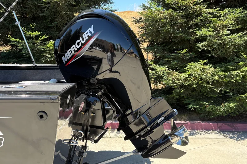 Slide: The Image of 2026 Tracker Targa V-18 Combo with Mercury outboard motor, parked near lush greenery. - 11