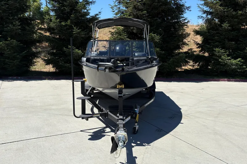 Slide: The Image of 2026 Tracker Targa V-18 Combo boat on trailer, parked outdoors with trees in background. - 9