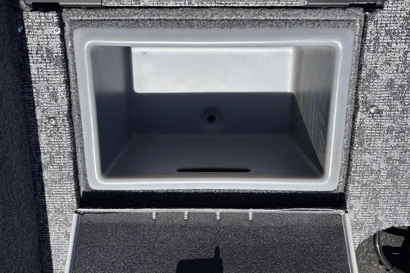 Slide: The Image of 2026 Tracker Targa V-18 Combo storage compartment, open and empty, with textured interior. - 46