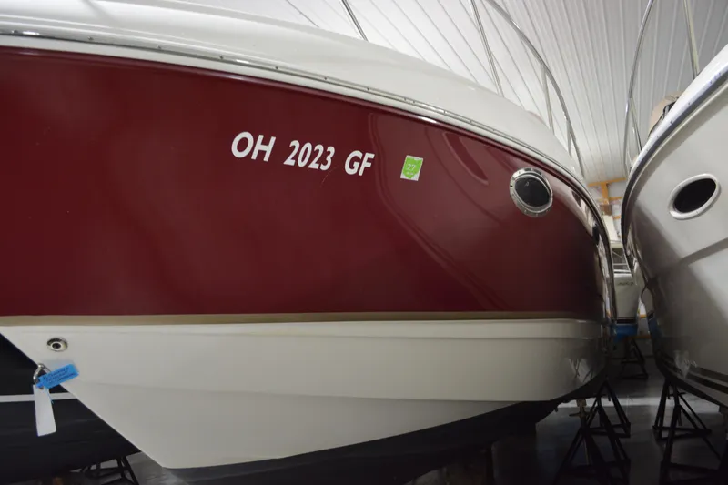 Slide: The Image of 2004 Chaparral Signature 290 boat in storage, red and white hull, registration visible. - 11