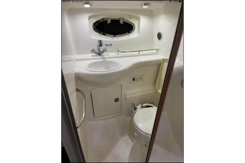 Slide: The Image of 2004 Chaparral Signature 290 boat bathroom with sink, toilet, and porthole window. - 41