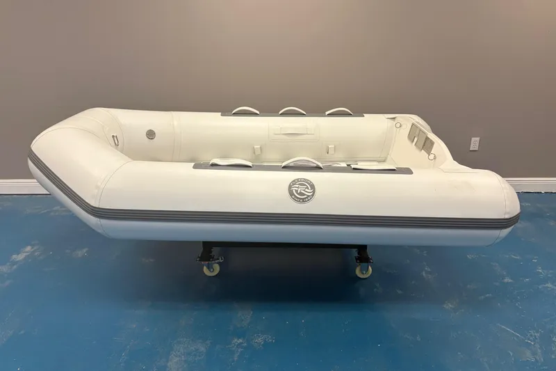 Slide: The Image of 2025 Flexboat TD-8 inflatable boat displayed indoors with motor and promotional signage. - 1