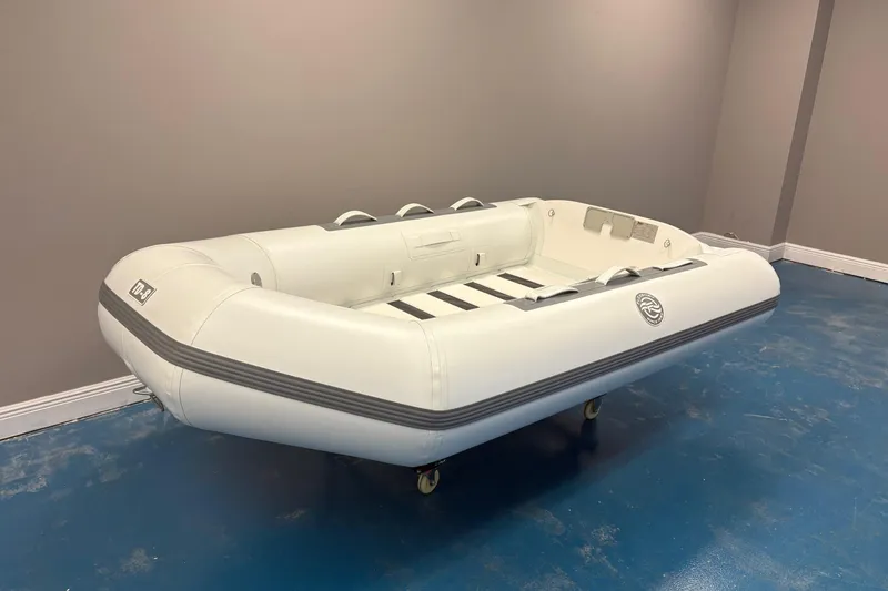 Slide: The Image of 2025 Flexboat TD-8 inflatable dinghy displayed indoors with plants and signage. - 2