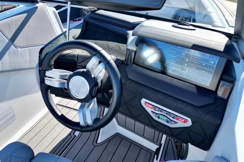 Slide: The Image of 2023 Nautique Super Air Nautique GS22 dashboard with touchscreen and steering wheel. - 11