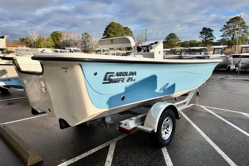 Slide: The Image of 2026 Carolina Skiff 21 LS boat in a parking lot, light blue hull, on a trailer. - 7