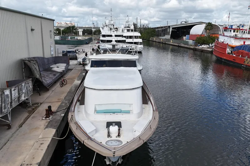 Slide: The Image of 1990 Denison Pilothouse Cockpit Motoryacht docked in a marina, surrounded by other boats. - 11