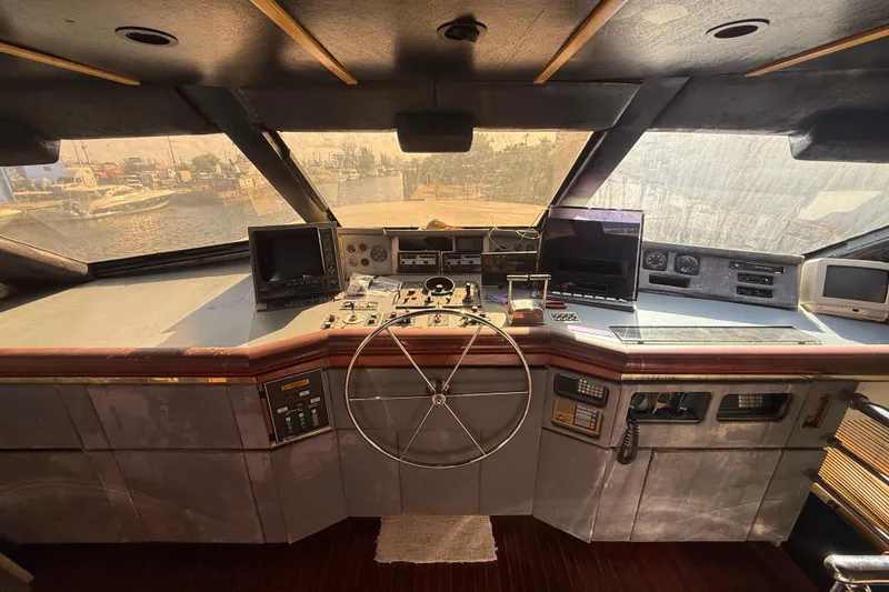 Slide: The Image of 1990 Denison Pilothouse Cockpit Motoryacht helm with steering wheel and navigation equipment. - 22