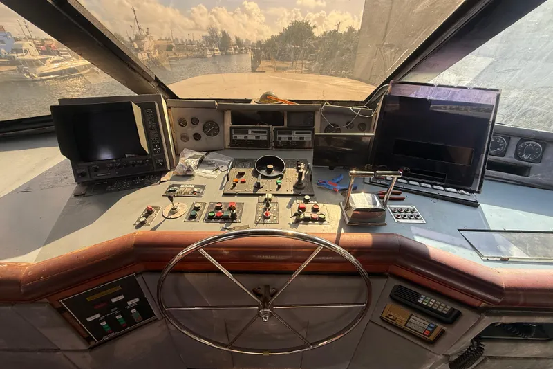 Slide: The Image of Cockpit of a 1990 Denison Pilothouse Cockpit Motoryacht with navigation equipment and controls. - 23