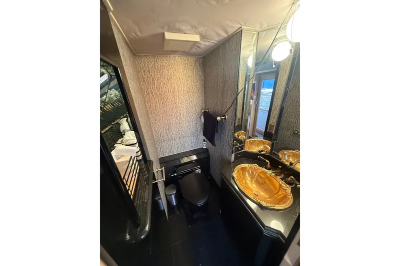 Slide: The Image of Luxurious bathroom in 1990 Denison Pilothouse Cockpit Motoryacht with gold sink and modern fixtures. - 25