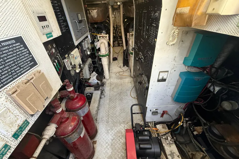 Slide: The Image of Engine room of a 1990 Denison Pilothouse Cockpit Motoryacht with control panels and equipment. - 27