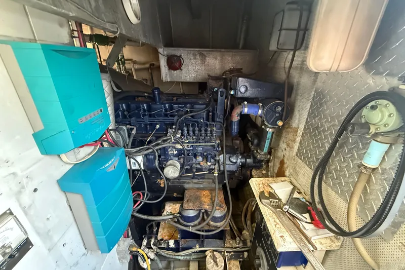 Slide: The Image of Engine room of a 1990 Denison Pilothouse Cockpit Motoryacht, featuring mechanical components and tools. - 28