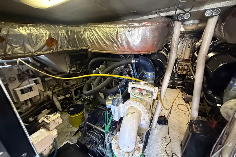 Slide: The Image of Engine room of a 1990 Denison Pilothouse Cockpit Motoryacht, showcasing complex machinery and piping. - 32