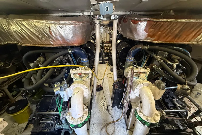 Slide: The Image of Engine room of a 1990 Denison Pilothouse Cockpit Motoryacht, showcasing complex machinery and piping. - 33