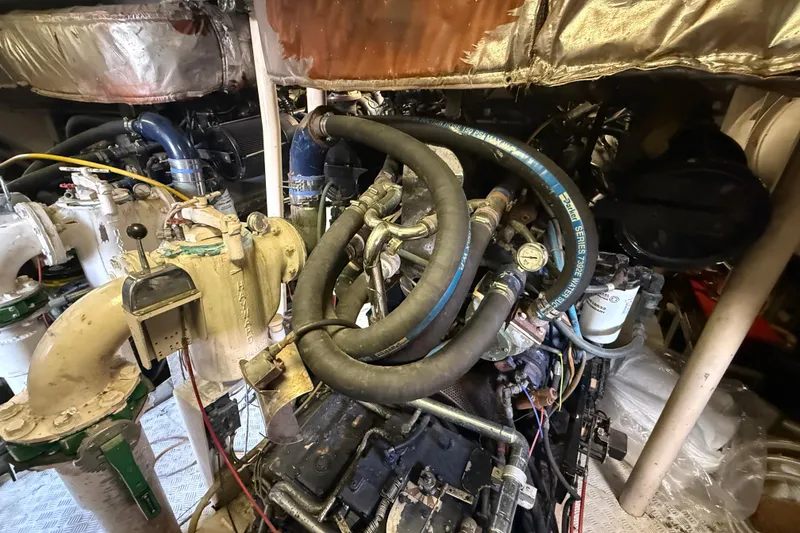 Slide: The Image of Engine room of a 1990 Denison Pilothouse Cockpit Motoryacht with complex piping and machinery. - 34
