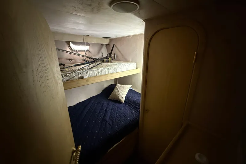 Slide: The Image of Cozy cabin interior of 1990 Denison Pilothouse Cockpit Motoryacht with bunk beds and fishing rods. - 46