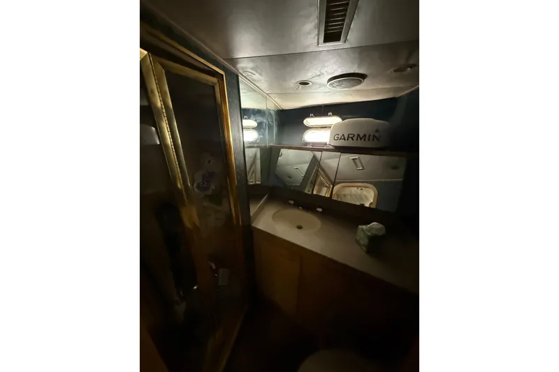 Slide: The Image of 1990 Denison Pilothouse Motoryacht bathroom with mirror, sink, and Garmin equipment. - 49