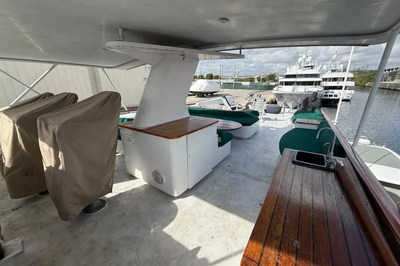 Slide: The Image of 1990 Denison Pilothouse Cockpit Motoryacht deck with seating, sink, and covered equipment. - 51