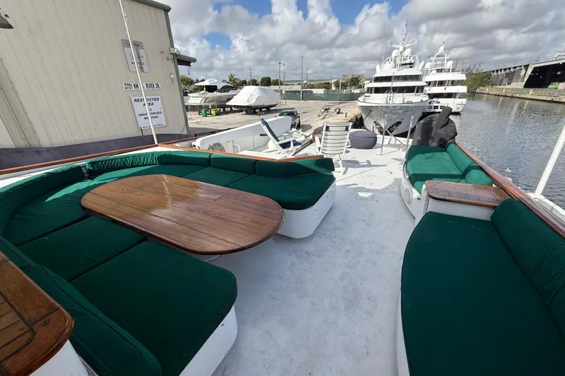 Slide: The Image of 1990 Denison Pilothouse Cockpit Motoryacht with spacious deck seating and wooden table. - 53