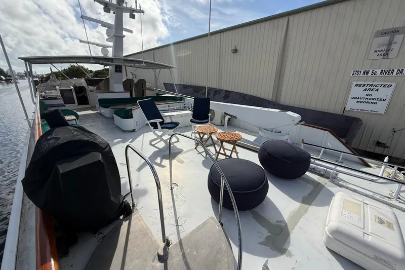 Slide: The Image of 1990 Denison Pilothouse Cockpit Motoryacht deck with seating and tables, docked at Miami River. - 55