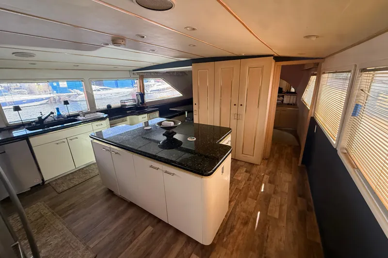 Slide: The Image of Luxurious interior of 1990 Denison Pilothouse Cockpit Motoryacht with modern kitchen and wood flooring. - 59