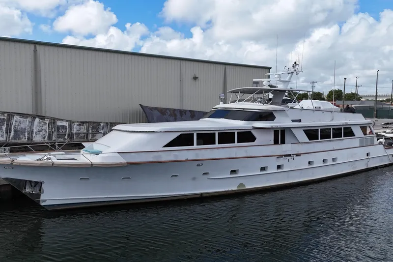 Slide: The Image of 1990 Denison Pilothouse Cockpit Motoryacht docked by industrial building under cloudy sky. - 7