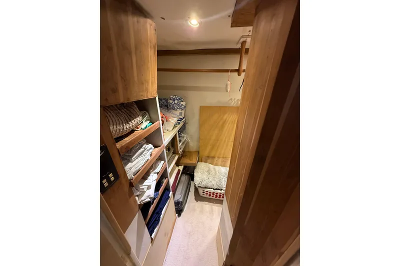 Slide: The Image of 1990 Denison Pilothouse Motoryacht interior with wooden shelves and cozy bedding. - 73