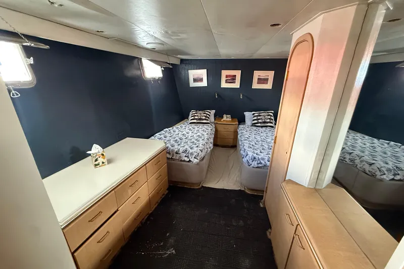 Slide: The Image of 1990 Denison Pilothouse Motoryacht cabin with twin beds, wooden furniture, and nautical decor. - 78