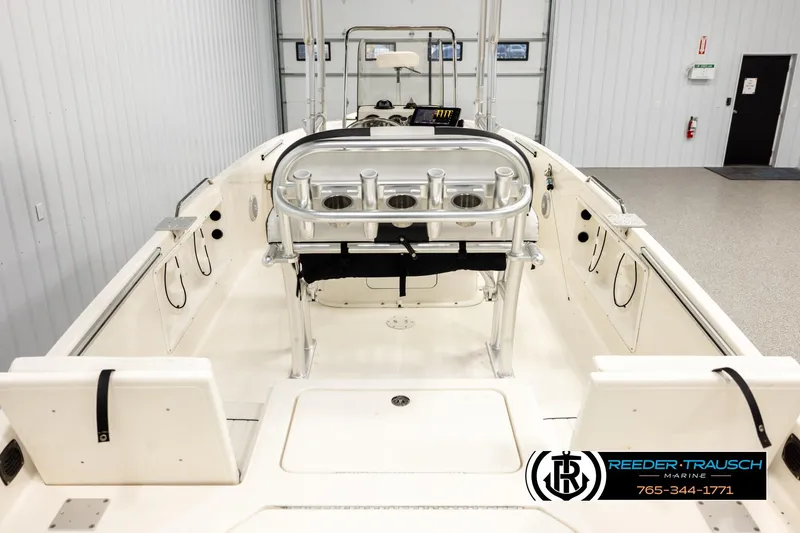 Slide: The Image of 2017 Bayliner Element F21 boat interior with rod holders and seating in a showroom. - 11