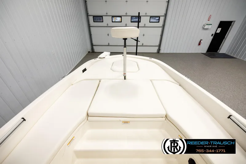 Slide: The Image of 2017 Bayliner Element F21 boat interior with cushioned seating in a showroom. - 13