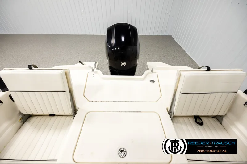 Slide: The Image of 2017 Bayliner Element F21 boat interior with seating and outboard motor in showroom. - 16