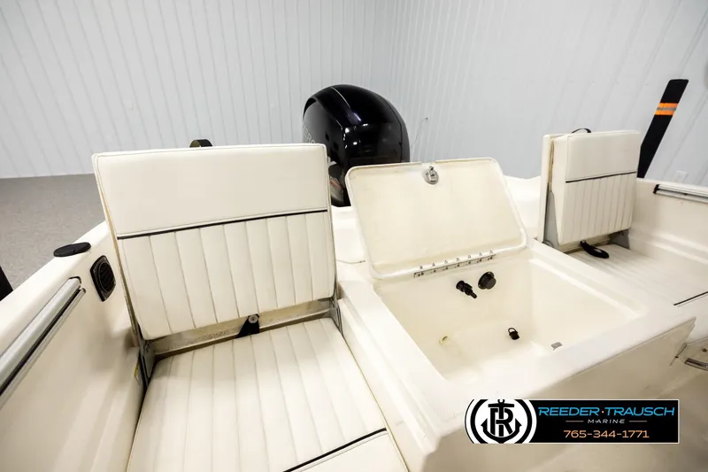 Slide: The Image of 2017 Bayliner Element F21 boat interior with white seating and storage compartment. - 18