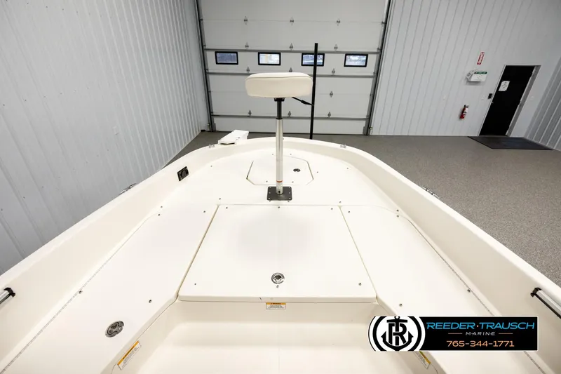 Slide: The Image of 2017 Bayliner Element F21 boat interior in a showroom, featuring spacious deck layout. - 21