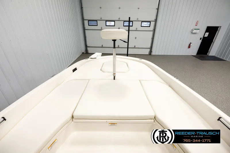 Slide: The Image of 2017 Bayliner Element F21 boat interior with white seating in a showroom. - 23