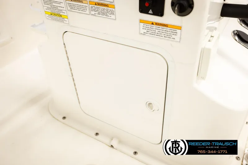 Slide: The Image of 2017 Bayliner Element F21 boat console with warning labels and storage compartment. - 40